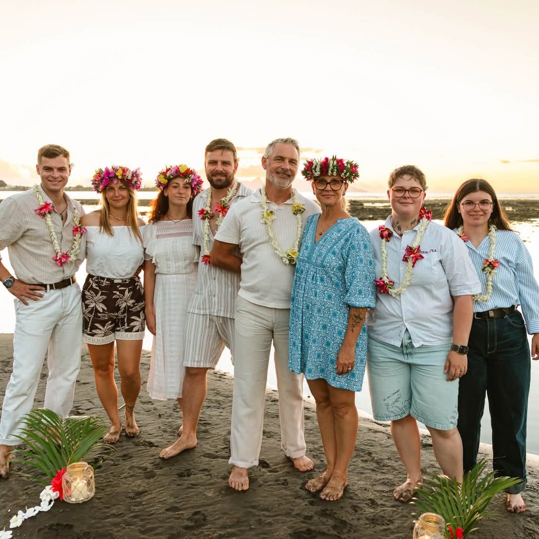 Famille et amis alignés sur la plage avec des bougies et des feuilles de cocotier